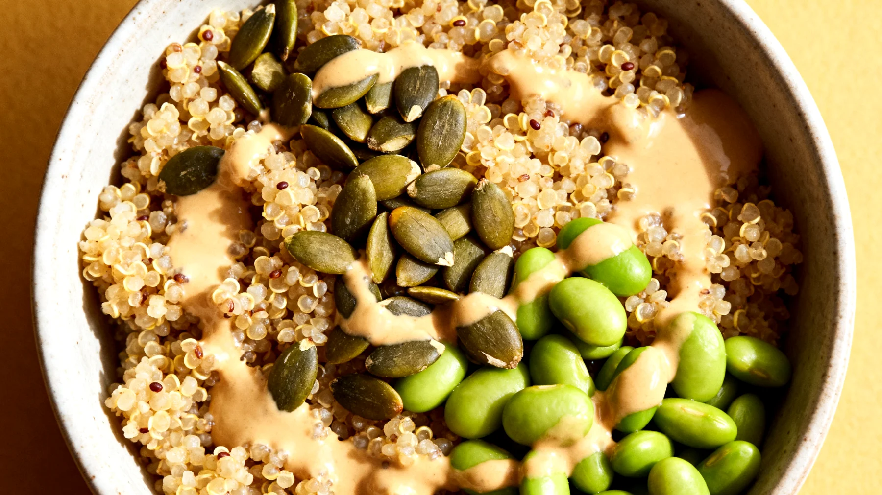 Amaranth-Quinoa-Bowl mit Kürbiskernen, Edamame und Tahini-Dressing"