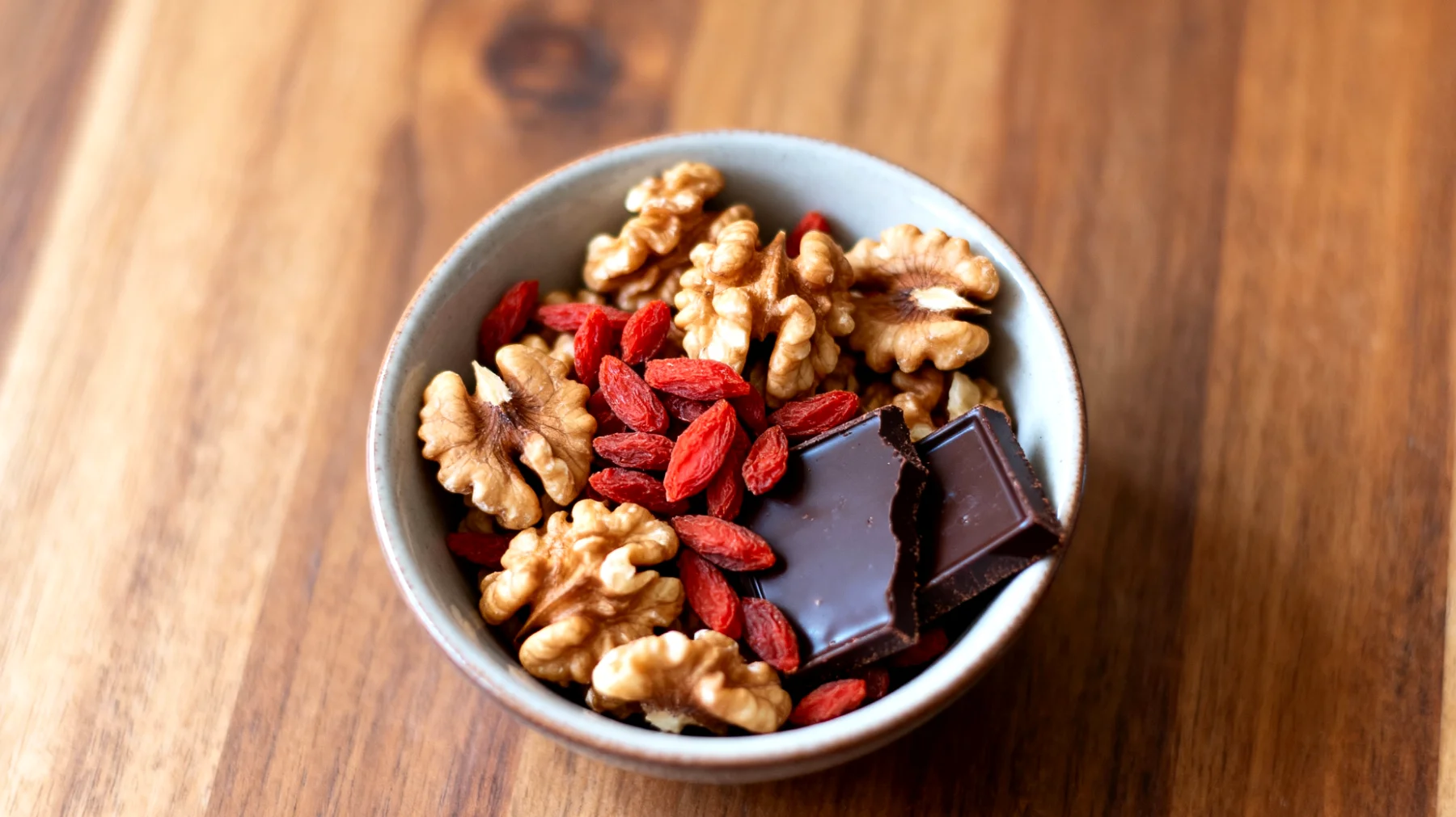Walnüsse mit getrockneten Goji-Beeren und dunkler Schokolade (85%)"